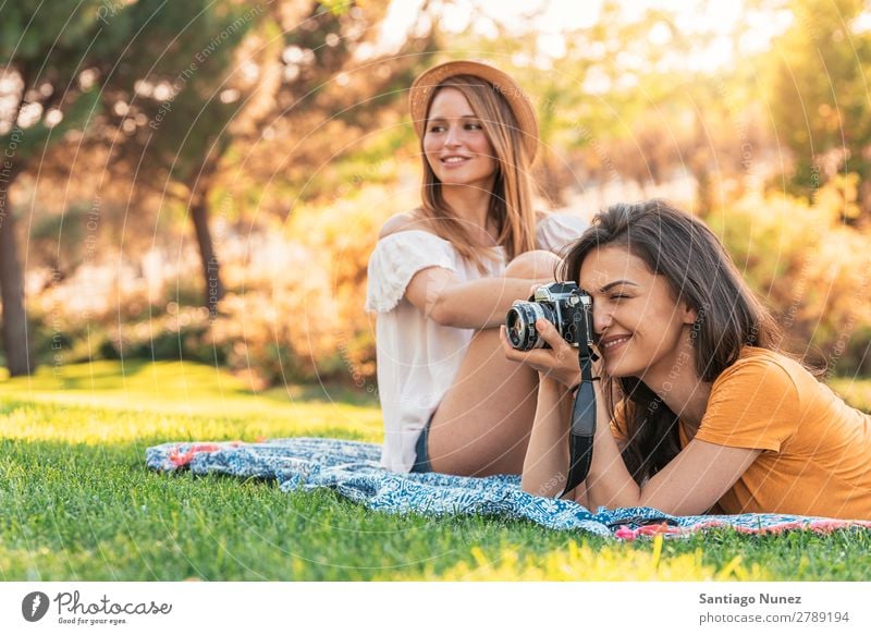 Schöne Frauen, die Spaß daran haben, jede Art von Fotografie im Park zu machen. Picknick Freundschaft Jugendliche Glück Sitzung nehmen Fotokamera Linse Sommer