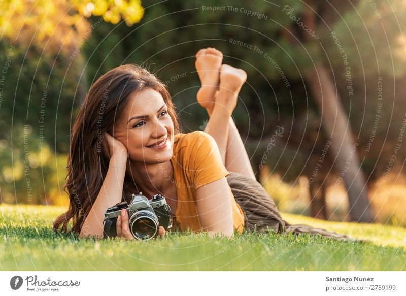 Lächelnde junge Frau, die eine Kamera benutzt, um Fotos zu machen. Fotograf Fotografie Fotokamera Jugendliche Mädchen digital weiß Freizeit & Hobby 1 nehmen
