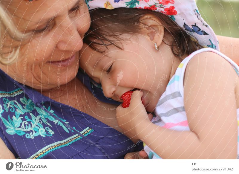 Erwachsene Frau hält ein Kind, das eine Erdbeere isst Lifestyle Freude Wellness Leben stimmig Wohlgefühl Zufriedenheit Sinnesorgane Erholung Windstille