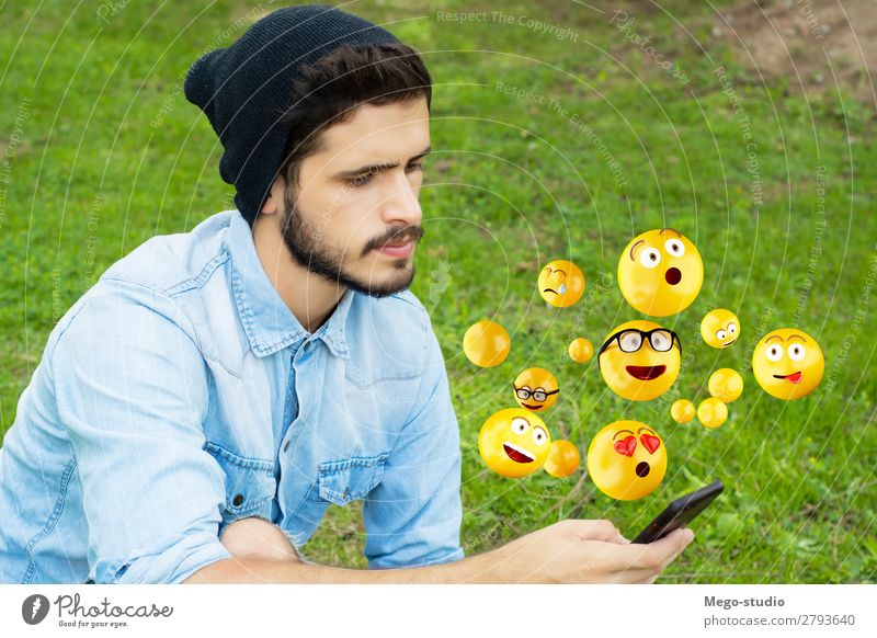 Junger Mann, der mit dem Smartphone Emojis sendet. Lifestyle Glück Gesicht Telefon PDA Bildschirm Technik & Technologie Internet Mensch Erwachsene Hand lustig