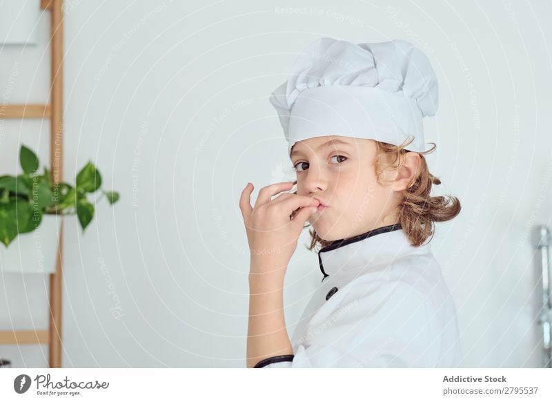 Junge mit Kochmütze mit leckerer Geste in der Küche Küchenchef Kind Hut Coolness gestikulieren kochen & garen modern heimwärts Feinschmecker zeigen Licht