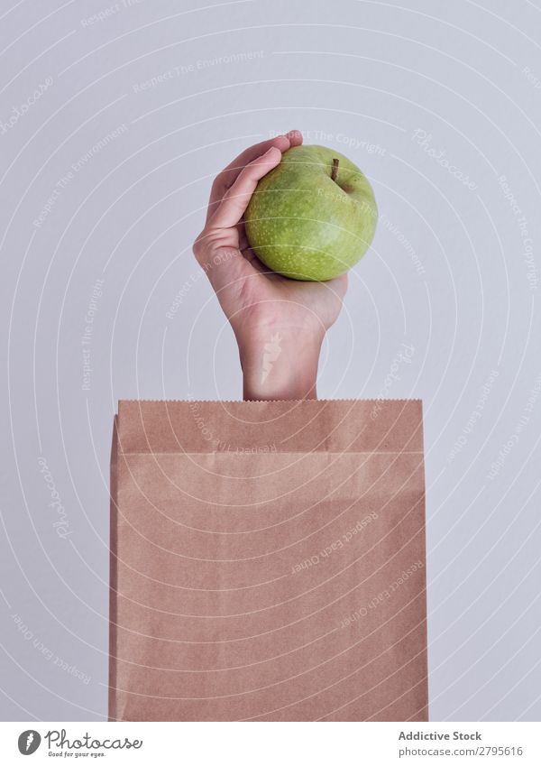 Personenhand aus der Packung ausgestreckt und hält den Apfel. Mensch Hand Möhre Paket sich[Akk] gemeldet Gemüse Lebensmittel Tasche Handwerk Papier frisch Markt