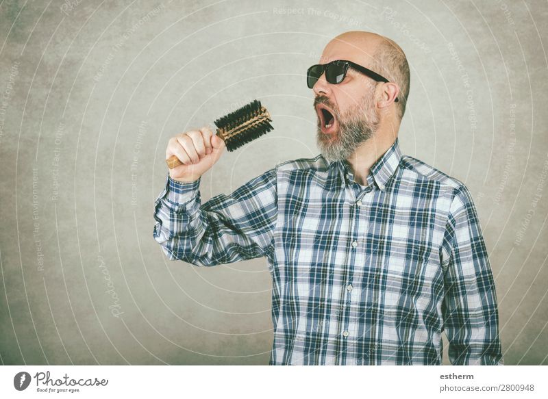 Mann mit Sonnenbrille singt eine Haarbürste vor grauem Hintergrund Lifestyle Behandlung Musik Feste & Feiern Mensch maskulin Erwachsene Vater 1 45-60 Jahre