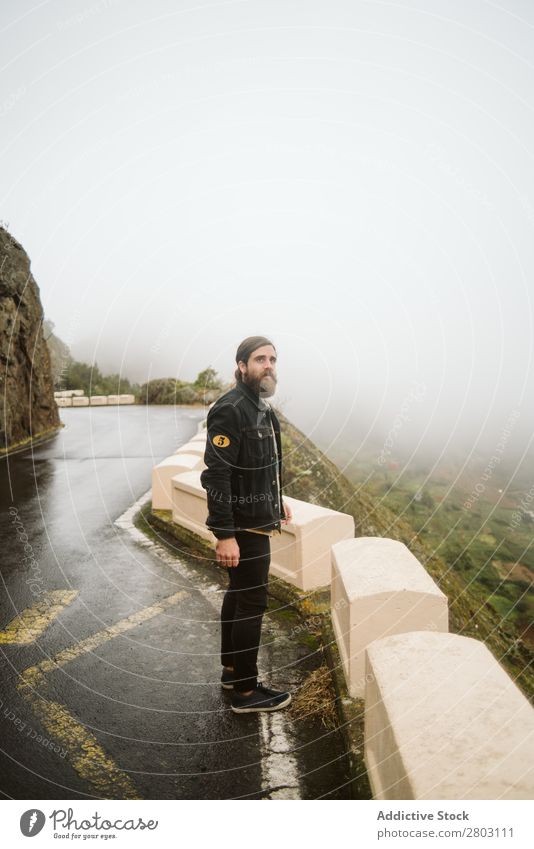 Anonymer Mann, der auf einer Klippe in der Nähe der Landstraße steht. Nebel Landschaft Straße Spanien playa norte Felsen Ferien & Urlaub & Reisen erkunden