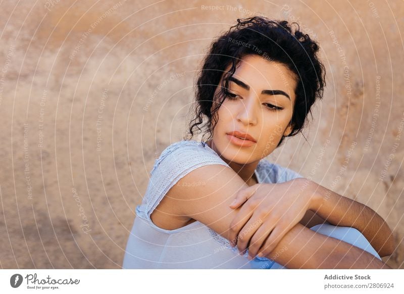 Schöne ethnische Frau in der Nähe einer schäbigen Mauer. Marokkaner Wand urwüchsig elegant anlehnen Außenseite Gebäude Jugendliche Model dünn dreckig genießen