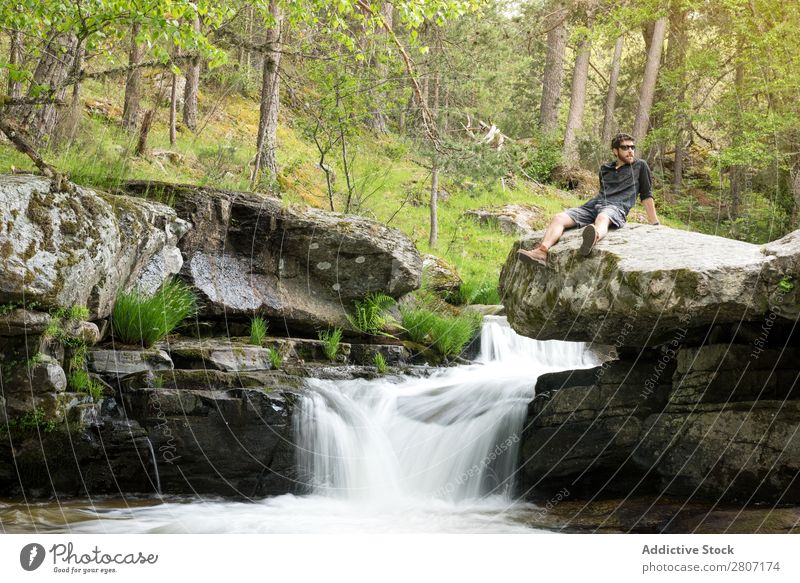 Junger Mann ruht sich nach dem Abenteuer am Wasserfall aus. Natur Sommer Ferien & Urlaub & Reisen genießend Gesundheit Körper Entwurf grün frisch gutaussehend