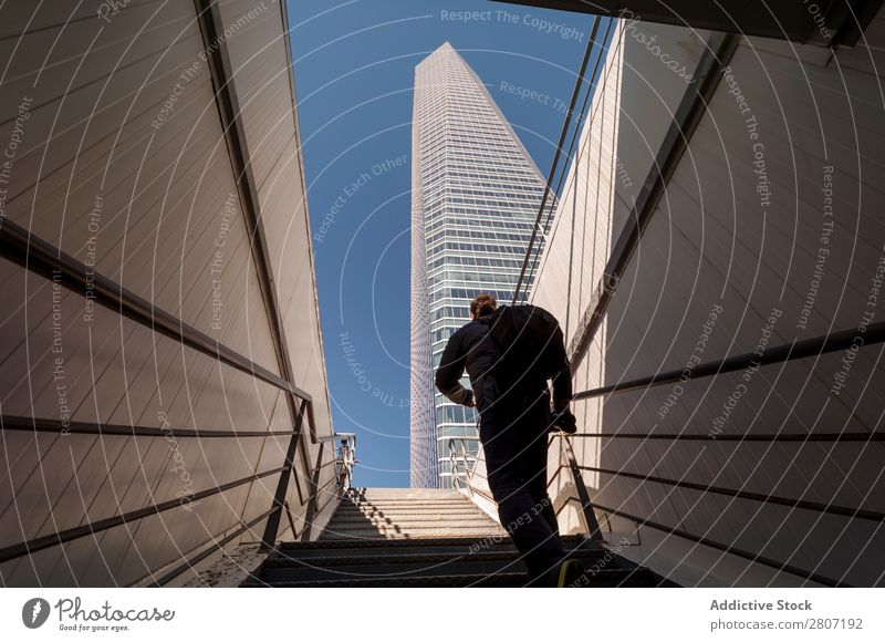 Mann steigt die Treppe zum Wolkenkratzer hinauf - 3 Büro Großstadt Hochhaus Mensch Außenseite modern Business Zentrum nach oben Madrid Erfolg Stadt Skyline