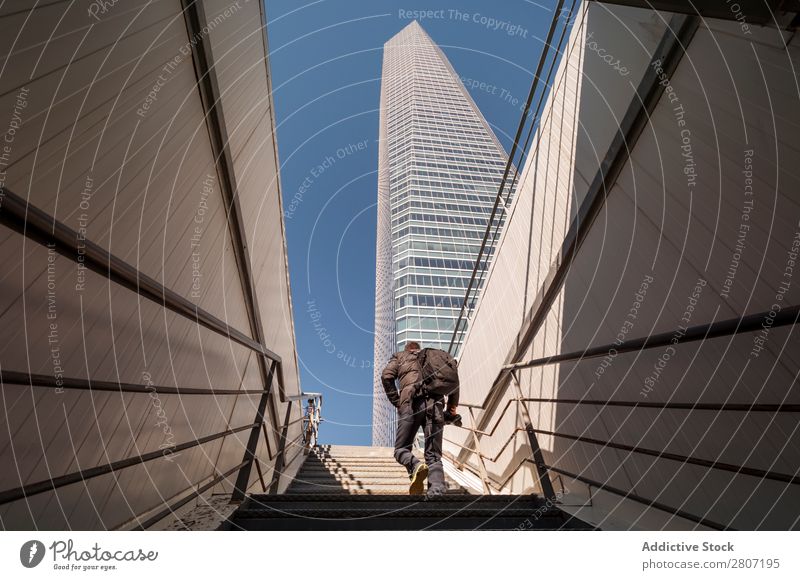 Mann steigt die Treppe zum Wolkenkratzer hinauf - 8 Büro Großstadt Hochhaus Mensch Außenseite modern Business Zentrum nach oben Madrid Erfolg Stadt Skyline