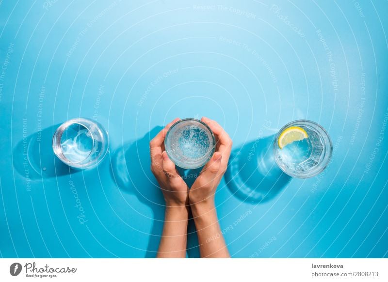 Die Hände der Frau halten eine Tasse sauberes Mineralwasser. frisch Sauberkeit Flasche Objektfotografie Getränk kalt Sommer Becher Glas Verschiedenheit
