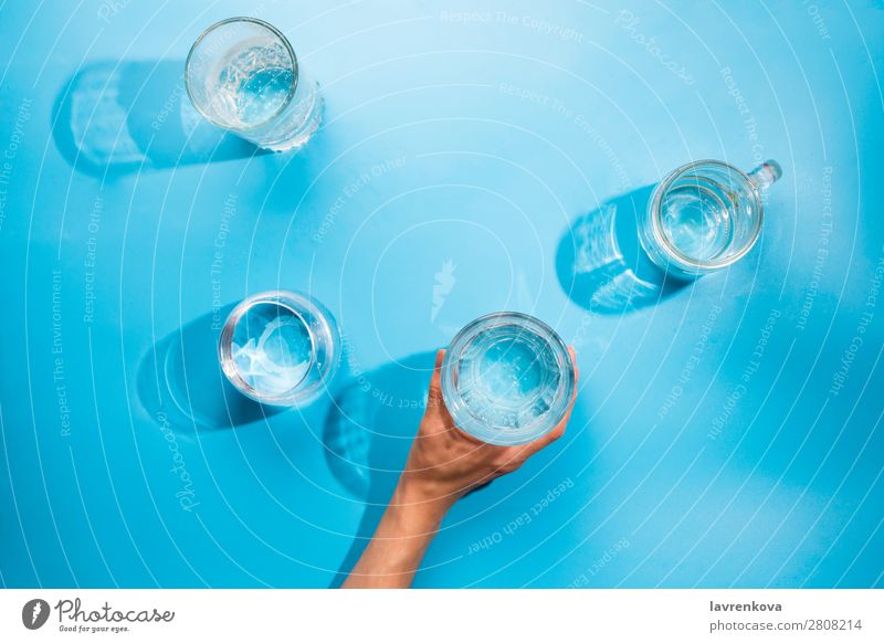 Die Hände der Frau halten eine Tasse sauberes Mineralwasser. Reflexion & Spiegelung Gesundheit frisch Coolness rein blau hell durchsichtig Urelemente Tropfen