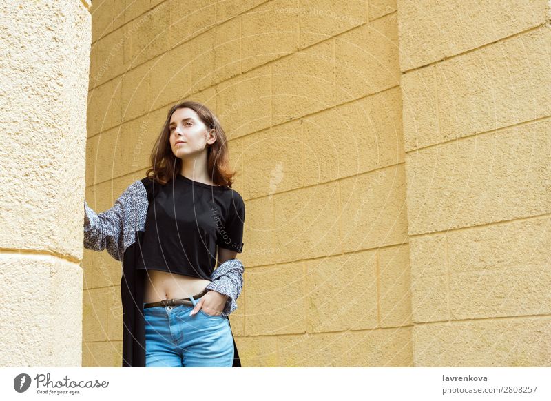 Porträt einer jungen erwachsenen Frau vor der gelben Wand Erwachsene attraktiv schön Freizeitbekleidung Kaukasier Großstadt Gesicht Mode Junge Frau Behaarung