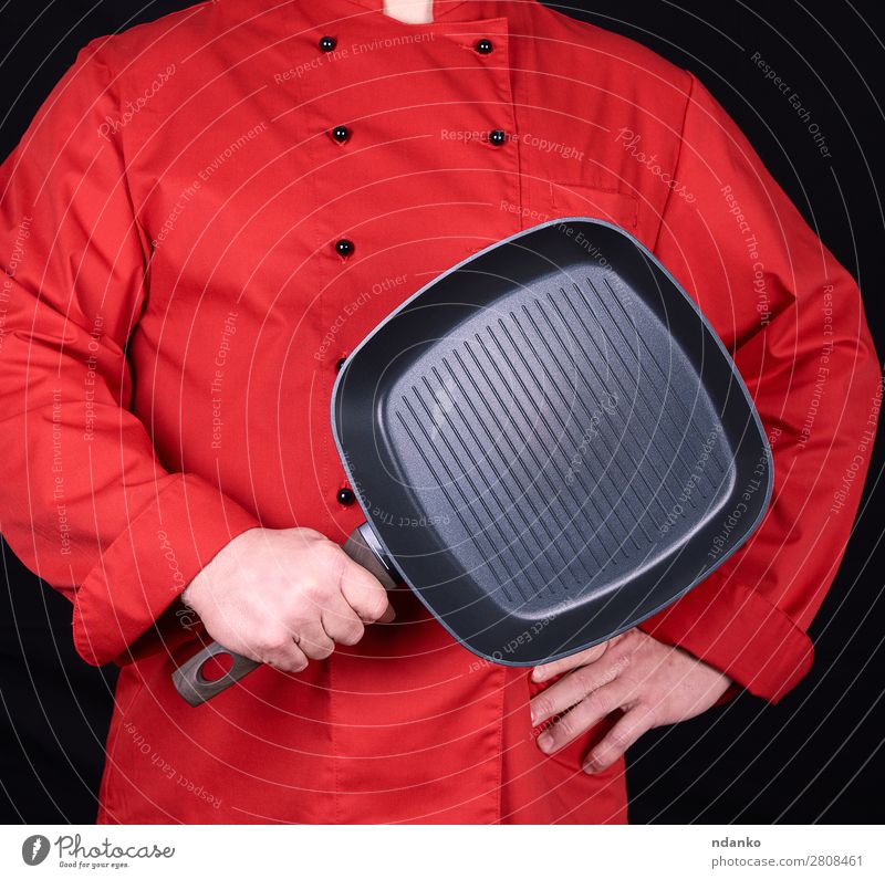 Koch mit einer leeren quadratischen schwarzen Bratpfanne Pfanne Küche Restaurant Mensch Mann Erwachsene Hand Bekleidung rot Gußeisen Kaukasier Küchenchef