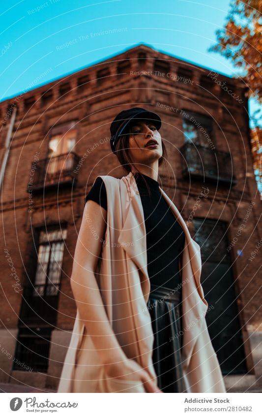 Sinnlich stilvolle Frau auf der Straße Stil Jugendliche Backstein Gebäude Hände in den Taschen Mütze schön Großstadt Mode hübsch attraktiv Model Mensch