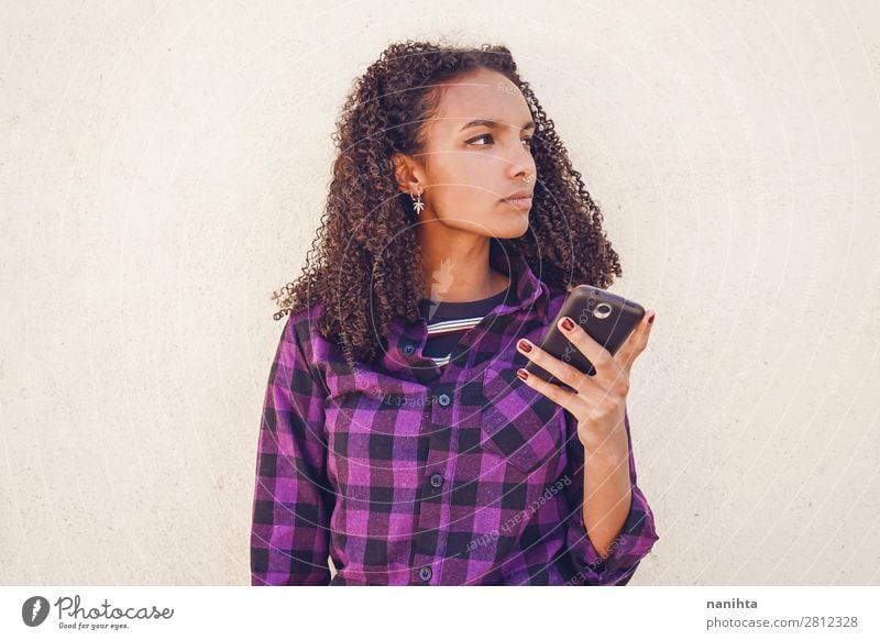 Junge Freizeitfrau mit Smartphone Jugend Frau cool WiFi Internet Technologieaufruf Nachricht Mitteilung jung Teenager schwarz Afrikanisch Afroamerikaner