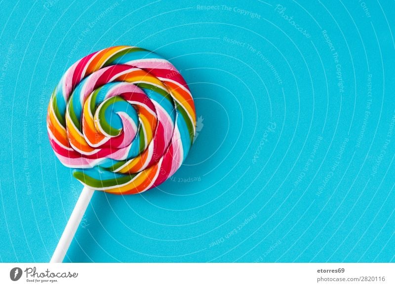 Bunte Lollis auf blauem Hintergrund. Draufsicht. Kopierbereich Lollipop Farbe mehrfarbig Zucker Süßwaren Bonbon süß geschmackvoll Hintergrund neutral