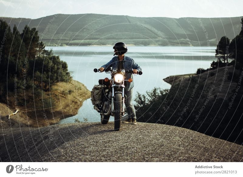 Mann auf dem Fahrrad posiert in der Landschaft Motorrad Felsen Klippe Fernweh Verkehr Ferien & Urlaub & Reisen See Motorradsportler stehen Freiheit Bahn