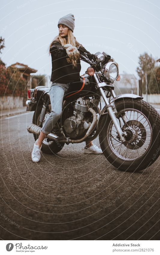 Junges rebellisches Mädchen, das auf dem Motorrad posiert. Frau ernst Leder selbstbewußt Verkehr Reiter Rebell einzigartig Lifestyle Ferien & Urlaub & Reisen