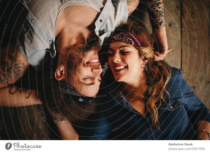 Glückliches Paar auf Holzuntergrund Porträt oben Hintergrundbild lügen Vogelperspektive Lächeln Fröhlichkeit heiter Stirnband Band Stil lachen Augen geschlossen