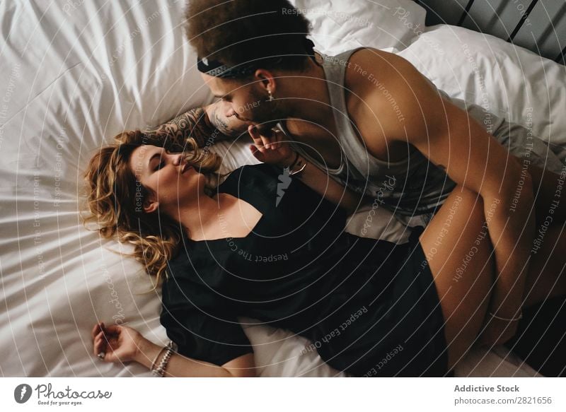 Mann berührt sinnlich seine Freundin im Bett. Paar Schlafzimmer itim Vogelperspektive oben Intimität Kittel Erotik genießen Beine Lächeln berühren Angebot