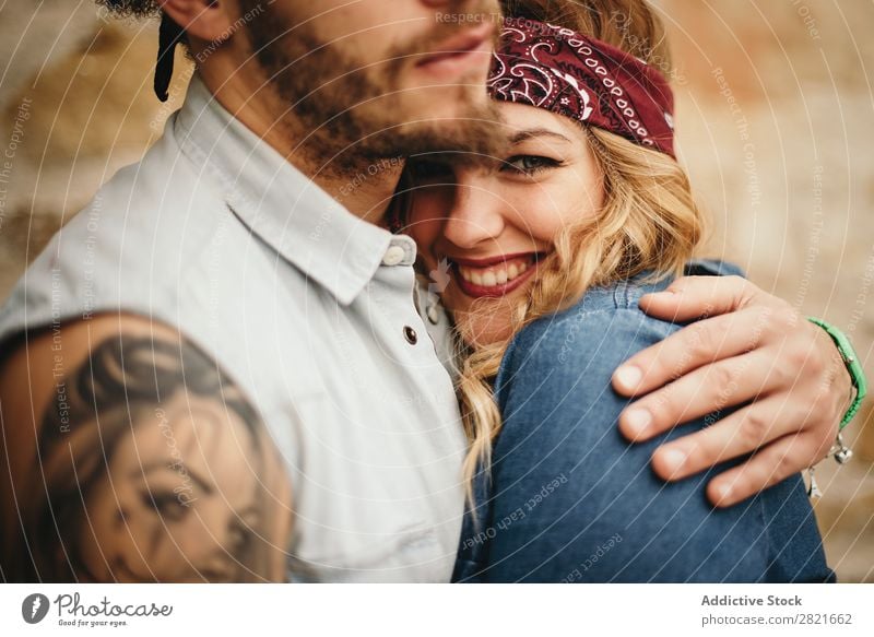 hübsche Freundin mit Band auf dem Kopf in der Umarmung von Freunden Paar Lächeln Nahaufnahme Blick in die Kamera Umarmen Hand Fokus Tattoo Porträt Gesicht