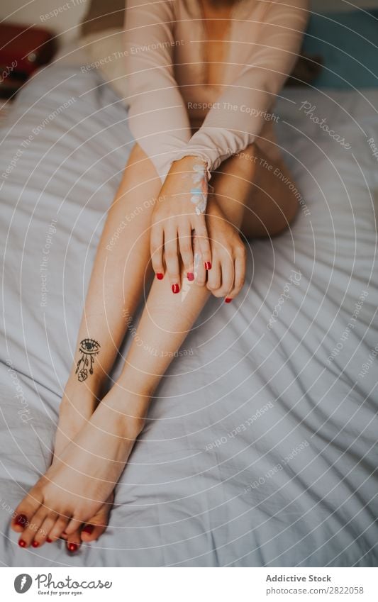 Zuschneiden attraktive Frau auf dem Bett hübsch heiß verführerisch Tattoo sitzen Schlafzimmer Arme Glück schön Jugendliche Beautyfotografie Lifestyle niedlich