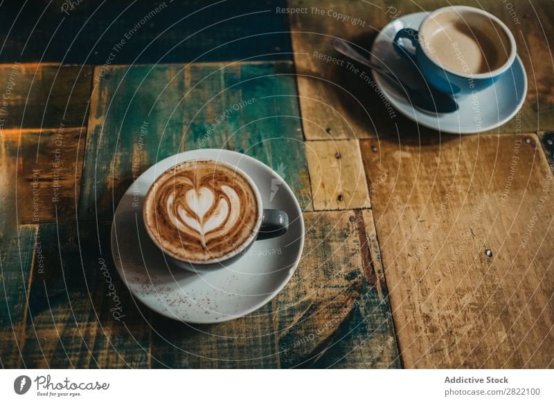 Tasse Latte mit Blume Kaffee Tisch trinken heiß braun Schaum Café Cappuccino Frühstück Becher Keramik blau Getränk Lebensmittel frisch Kunst Untertasse Holz
