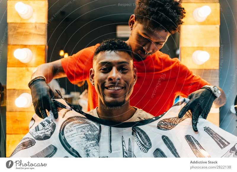 Fröhlicher Kunde im Friseursalon Haarkleid Behaarung Salon Umhang anmachend schwarz Mann Jugendliche Klient Haare schneiden Haare & Frisuren Fürsorge