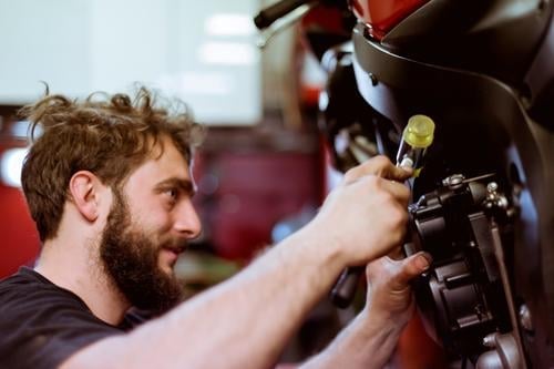 Mann, der am Fahrrad arbeitet Flugzeugwartung Detailaufnahme Teile u. Stücke Mitarbeiter Motorrad Werkstatt Mensch Verkehr Fahrzeug Garage benutzerdefiniert