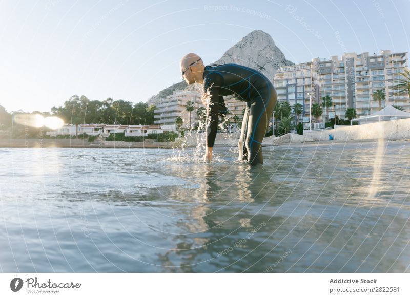 Taucher im flachen Wasser, der sich auf das Schwimmen vorbereitet. Mann Neoprenanzug Meer Ferien & Urlaub & Reisen Erholung Schwimmsport Aktion Sport Strand