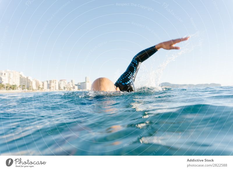 Mann im Neoprenanzug schwimmend im Meer Schwimmsport Sport Athlet Wassersport Bewegung Aktion Ferien & Urlaub & Reisen Rudern Freizeit & Hobby Sonnenlicht