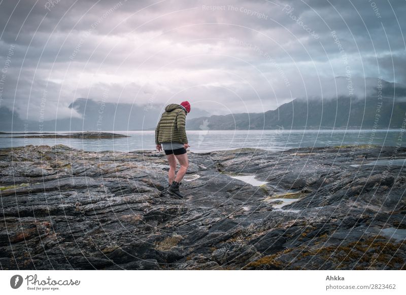 Melancholisch gestimmter Spaziergänger an der Nordmeerküste Himmel Wolken Nachthimmel schlechtes Wetter Berge u. Gebirge Küste Fjord Norwegen laufen Stimmung