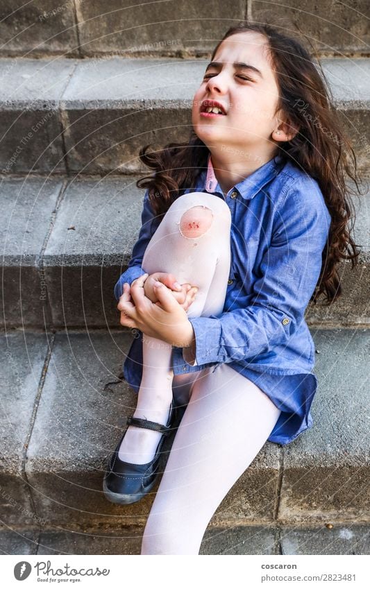Kleines Mädchen weint mit einer Wunde am Knie. Lifestyle Haut Gesundheitswesen Krankenpflege Medikament Spielen Sommer Sport Verlierer Kind Schule Schulkind
