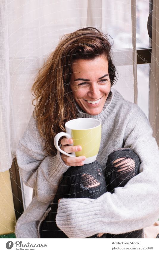 Fröhliche Frau entspannt sich bei einer Tasse. heimwärts Erholung Lifestyle Becher trinken heiß Lächeln Kaffee Tee schön Raum Mensch lässig Erwachsene Haus