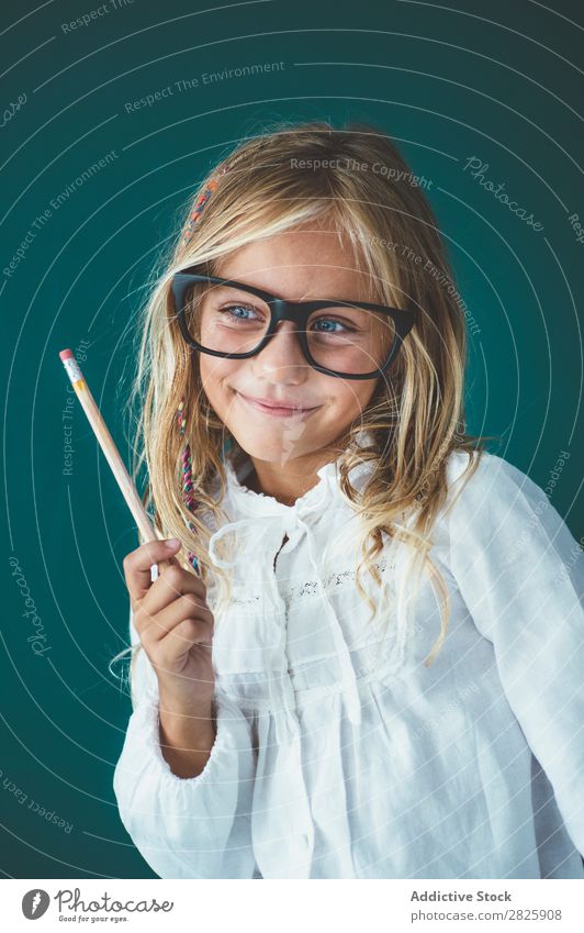 Niedliches Schulmädchen mit Bleistift Mädchen Klassenraum Tafel Brillenträger Lächeln heiter stehen niedlich Bildung Schule Schulklasse Schüler Jugendliche