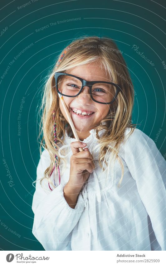 Niedliches Schulmädchen mit Bleistift Mädchen Klassenraum Tafel Brillenträger Blick in die Kamera Lächeln heiter stehen niedlich Bildung Schule Schulklasse