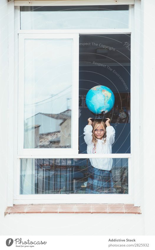 Schulmädchen posiert mit Globus Mädchen Klassenraum Fenster Landkarte Körperhaltung stehen niedlich Bildung Schule Schulklasse Schüler Jugendliche lernen Kind