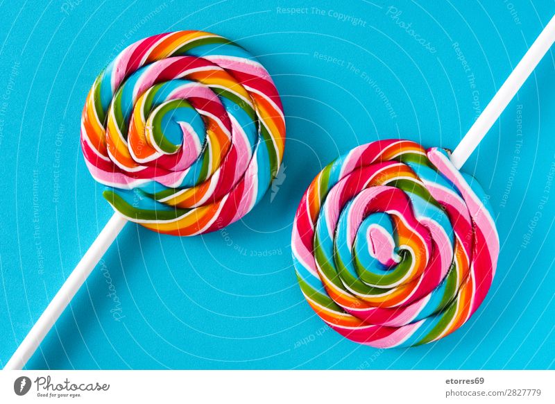 Bunte Lollis auf blauem Hintergrund. Lollipop Farbe mehrfarbig Zucker Süßwaren Bonbon süß geschmackvoll Hintergrund neutral Textfreiraum Lebensmittel