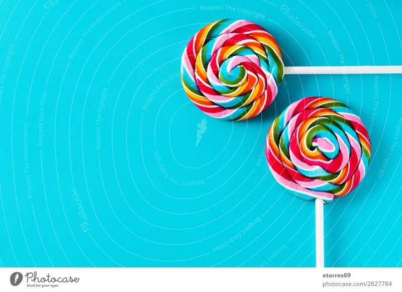 Bunte Lollis auf blauem Hintergrund. Draufsicht. Kopierbereich Lollipop Farbe mehrfarbig Zucker Süßwaren Bonbon süß geschmackvoll Textfreiraum Lebensmittel