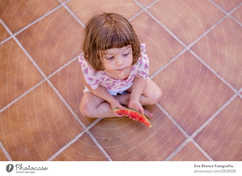 Draufsicht auf ein schönes Kind Mädchen beim Essen von Wassermelone Frucht Speiseeis Freude Glück Ferien & Urlaub & Reisen Sommer Haus Garten feminin Baby