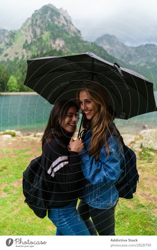 Frauen unter Schirm in den Bergen Berge u. Gebirge Zusammensein stehen Lächeln wandern See Wasser Regenschirm heiter Glück Ferien & Urlaub & Reisen Abenteuer