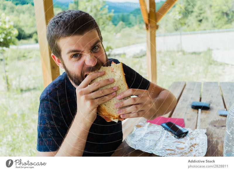 Ausdrucksstarker Mann mit Sandwich Essen Wut so tun, als ob Spaß haben Appetit & Hunger expressiv verrückt Körperhaltung Gesichtsbehandlung Verstand spielerisch