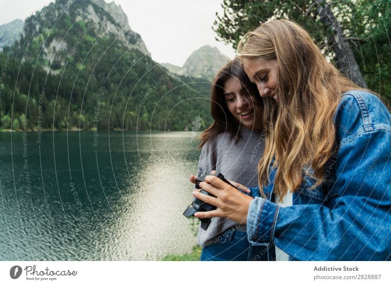 Frauen mit Kamera in den Bergen Berge u. Gebirge laufen Fotokamera Fotograf Körperhaltung See Wasser nehmen Zusammensein Lächeln wandern heiter Glück