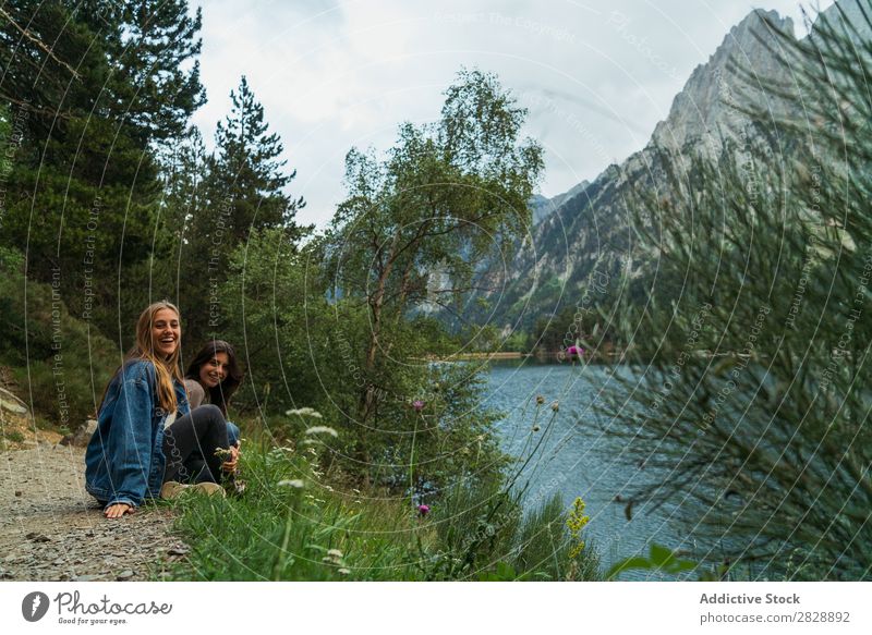 Fröhliche Frauen am See sitzend Berge u. Gebirge Lächeln heiter Zusammensein Glück lachen wandern Wasser Ferien & Urlaub & Reisen Abenteuer Tourist Jugendliche