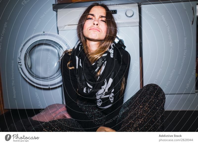 Frau, die an der Waschmaschine sitzt. hübsch Körperhaltung heimwärts Wäsche Maschine Bekleidung sitzen Küche schön Lifestyle Jugendliche Mensch Glück attraktiv
