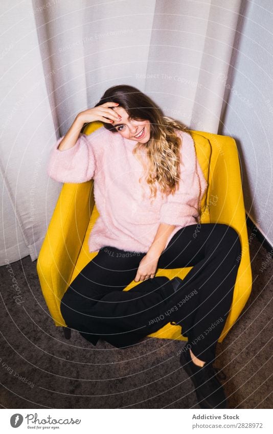 Junge Frau ruht sich auf einem Sessel aus. Jugendliche attraktiv heimwärts Pullover rosa sitzen lügen Glück expressiv Körperhaltung verführerisch schön Mensch