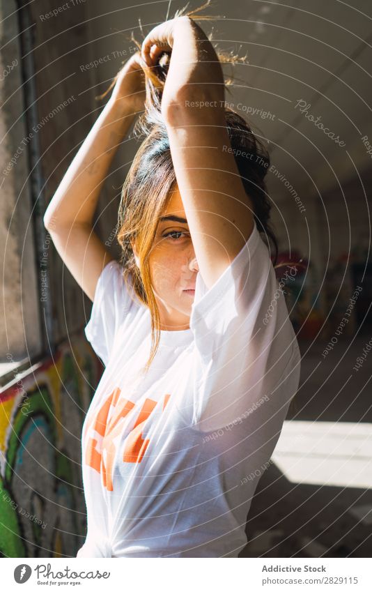 Lächelnde Frau in verlassenem Raum mit Graffiti heiter Körperhaltung Blick in die Kamera Jugendliche schäbig mehrfarbig hübsch lässig Verlassen Gebäude Erholung