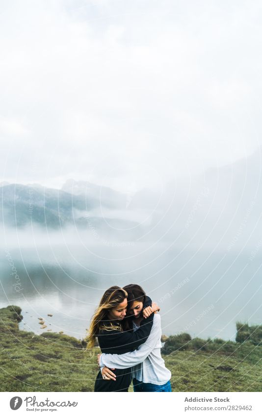 Frauen am nebligen See Wiese umarmend Nebel stehen Zusammensein Freundschaft Erholung Berge u. Gebirge Natur Feld Mädchen Gras schön Jugendliche grün Frühling