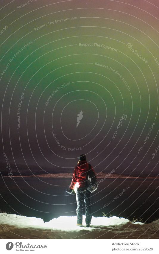 Stehende Person am zugefrorenen See Winter Natur kalt Norden Mensch Tourist Rucksack Polarlicht Nacht Wasser bedeckt Schnee Jahreszeiten weiß Landschaft Eis