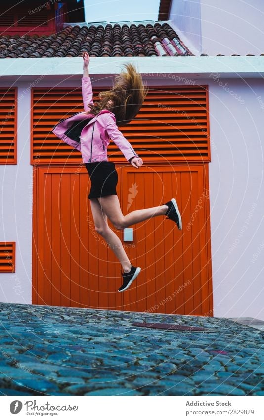 Stylisches Mädchen fliegt über den Boden Frau springen fliegen über der Erde Bewegung Straße nach oben Beautyfotografie wehendes Haar romantisch Stadt Ausdruck