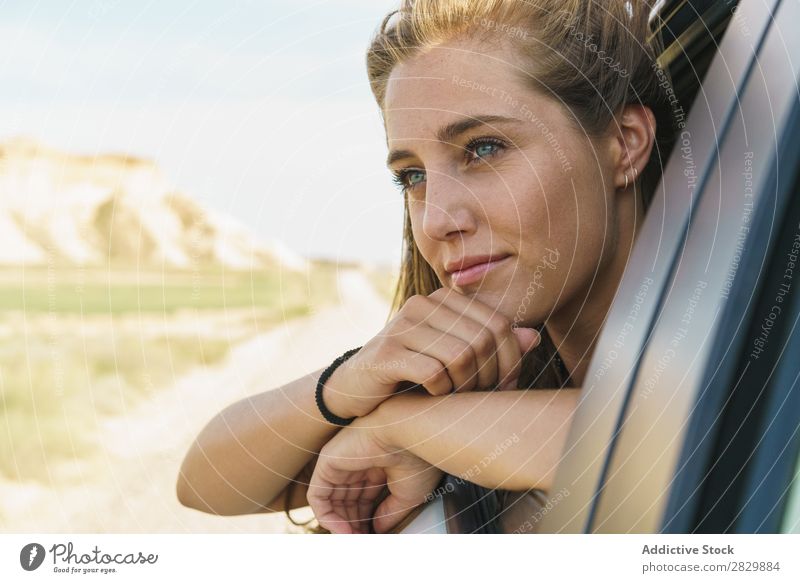 Frau, die aus dem Autofenster schaut. PKW Fenster Reiten Passagier Jugendliche Fahrzeug Ausflug Ferien & Urlaub & Reisen Mädchen Mensch Straße schön Gesicht